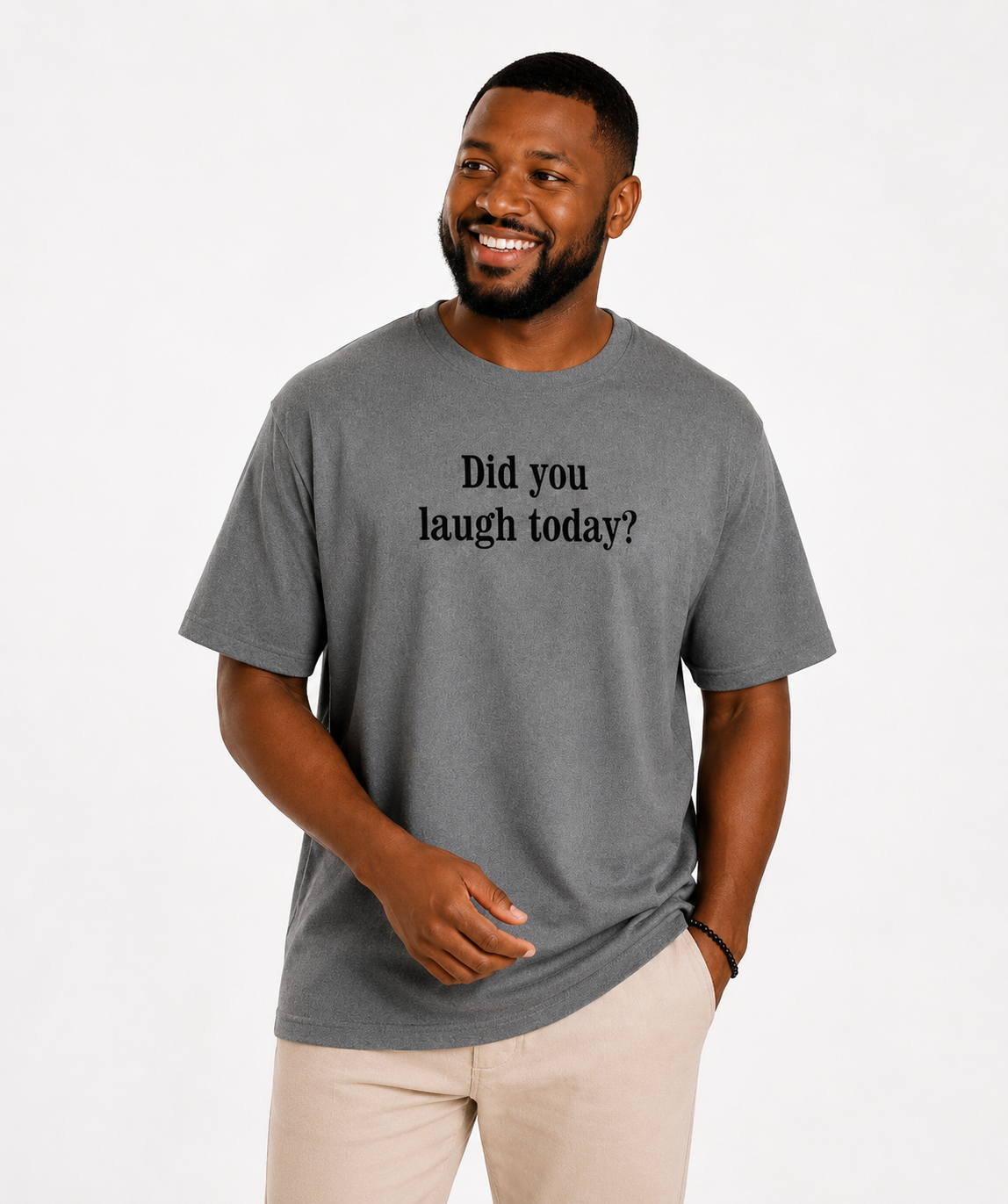 Man wearing a gray t-shirt with 'Did you laugh today?' text in a living room.