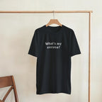 Black t-shirt with a colorful emblem design on a wooden hanger against a beige wall.